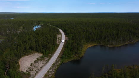 Drone-tracking-a-Motorhome-driving-in-the-wilderness-of-Naatamo,-Finland