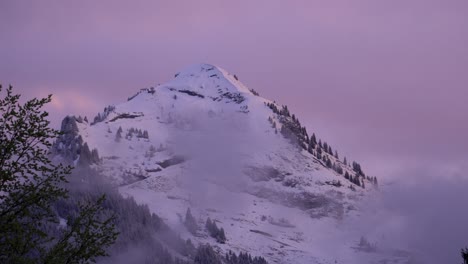 mountain-peak-Point-of-Nyon-timelapse-during-a-pink-and-purple-winter-sunset-and-low-clouds-turning-into-a-clear-night