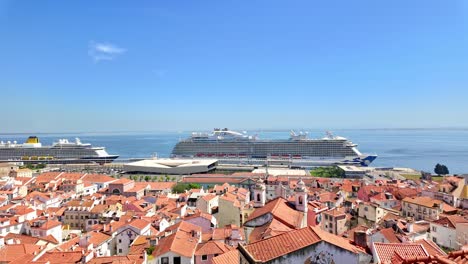 Lisbon-showing-rooftops-and-a-cruise-ship-docked-in-the-harbor,-clear-sunny-day,-aerial-view