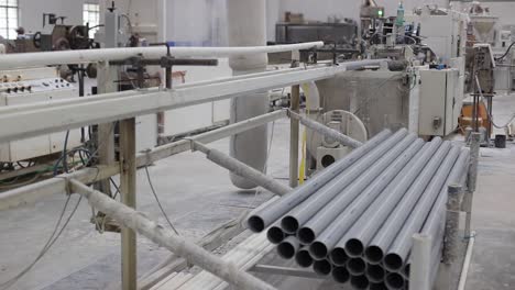 pov-shot-PVC-pipes-are-being-cut-to-size-and-stored-inside-a-large-machine