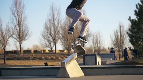 Una-Persona-Hace-Un-Kickflip-Sobre-Una-Barandilla-En-El-Skatepark.