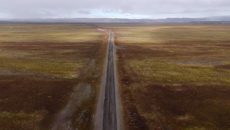 Endlose-Straße-Durch-Eine-Isländische-Heide,-Bedeckter-Himmel,-Entfernter-Horizont,-Luftaufnahme