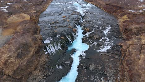 Bruarfoss-Wasserfall-In-Island-Mit-Leuchtend-Blauem-Gletscherwasser,-Luftaufnahme