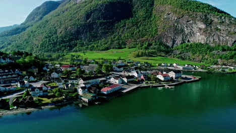 Drone-shot-of-Aurland,-Norway's-shoreline-with-houses-lining-the-waterfront