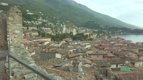 Erkunden-Sie-Die-Charmante-Stadt-Malcesine-Am-Gardasee-Mit-Ihrer-Mittelalterlichen-Und-Renaissance-Architektur-Vor-Der-Kulisse-Des-Ruhigen-Wassers-Und-Des-Dramatischen-Himmels