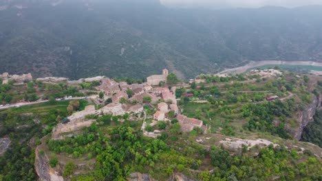 Ciudad-De-Siurana-Rodeada-De-Exuberantes-Paisajes-Y-Un-Río,-Luz-Del-Día,-Vista-Aérea