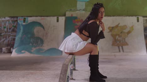Ein-Hispanisches-Mädchen-Im-Minirock-Erkundet-Mit-Stil-Den-Indoor-Skatepark