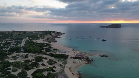 Playa-De-Cala-Comte-Con-Barcos,-Impresionante-Cielo-Al-Atardecer-En-Ibiza