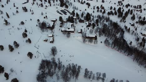 Aerial-Drone-Flyover-Snow-Covered-Norwegian-Lodging-Rondane,-Norway