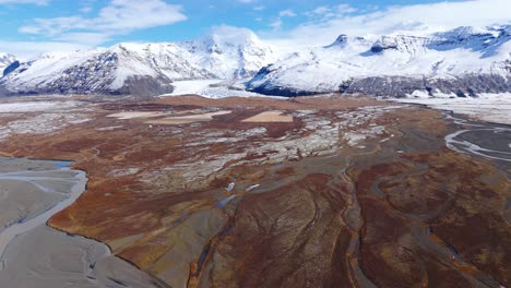 Icelandic-glacier-nature-with-brown-plains-and-frozen-snowy-mountains