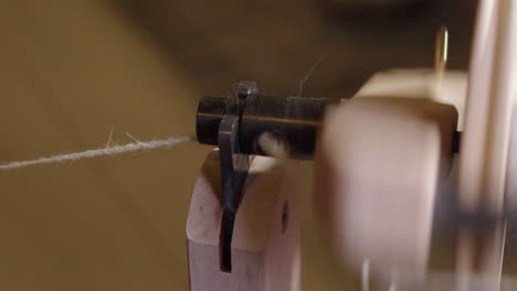 Spinning-wheel-detail-close-up:-Bobbin-eye-feeds-wool-into-machinery