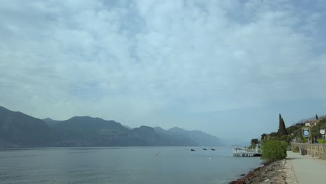 Recorra-En-Bicicleta-El-Sendero-Panorámico-Del-Lago-De-Garda,-Pasando-Por-Hoteles-Bajo-Un-Cielo-Nublado.