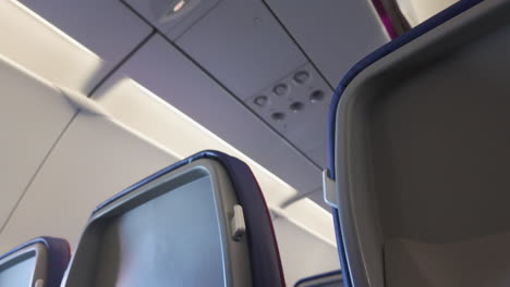 Perspective-view-between-rows-of-airplane-seats,-emphasizing-the-cabin-layout-and-seating-design