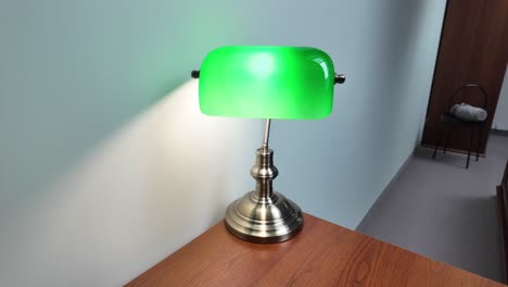 Green-Reading-Lamp-On-Wooden-Desk-In-The-Library