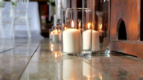 Decoraciones-En-La-Iglesia-Hechas-De-Velas-Encendidas-En-Jarrones-De-Vidrio-Para-La-Ceremonia-De-Boda.