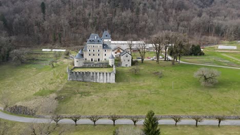 Large-castle-on-a-French-countryside-with-fruit-and-vegetable-gardens-and-symmetrical-trees-by-the-road-side