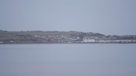 Port-Ellen-In-Distance,-Across-Hazy-And-Calm-Bay