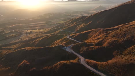 Viaje-Por-Carretera-En-Nueva-Zelanda,-Camino-Sinuoso-Y-Hermosa-Puesta-De-Sol-Sobre-Las-Montañas