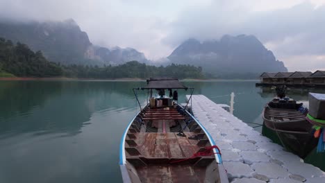 Morning-Boat-On-Lake-with-Misty-Fog-Mountain-in-Background,-Khao-Sok,-Thailand