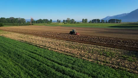 Traktor,-Der-Die-Felder-In-Wunderschönen-Landwirtschaftlichen-Parzellen-Bearbeitet-Und-Das-Land-An-Einem-Sonnigen-Morgen-Für-Die-Landwirtschaft-Kultiviert