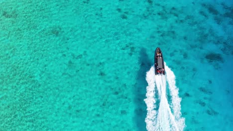 Drone-top-down-tracking-follows-dive-tour-inflatable-boat-above-Caribbean-sandy-reefs