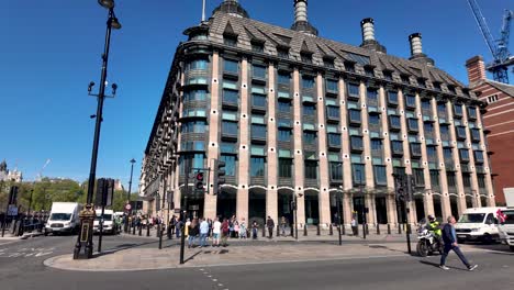 La-Gente-Y-El-Tráfico-Por-Carretera-En-La-Calle-Cerca-Del-Edificio-De-Oficinas-De-La-Casa-Rastrillo-En-Westminster,-Londres,-Inglaterra