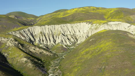 Geological-formations-foothills-with-rocky-cliff-grassland-at-carrizo-plains-drone-skyline-background,-daylight-shot-california-USA