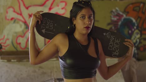 A-mini-skirted-Hispanic-girl-gliding-through-an-indoor-skatepark-with-her-skateboard