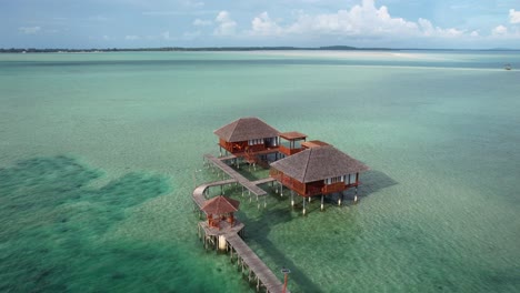luxury-over-water-villas-connected-to-a-wooden-bridge-in-a-tropical-landscape-on-a-sunny-day