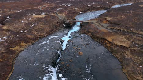 La-Vívida-Cascada-De-Bruarfoss-En-Islandia-Con-Aguas-Heladas-Y-Terreno-Rocoso,-Temporada-De-Invierno,-Vista-Aérea