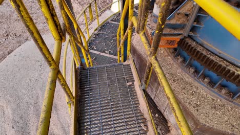 POV-Bajando-Un-Conjunto-De-Escaleras-Industriales-De-Metal-En-Una-Planta-Industrial