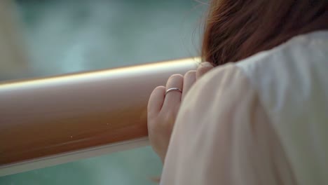 Woman's-hand-with-wedding-ring-on-the-cruise-ship-in-the-evening,-feeling-wind-and-ocean-close-up