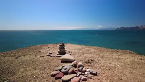 A-pyramid-of-stones-against-the-backdrop-of-the-green-waters-of-the-Black-Sea-and-the-blue-horizon