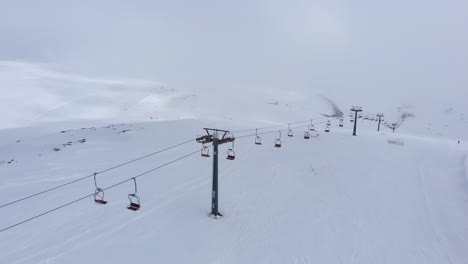 Drone-view-over-empty-of-people-ski-lifts-resort-snow-covered-slopes-Mountain-Kaimaktsalan-Greece