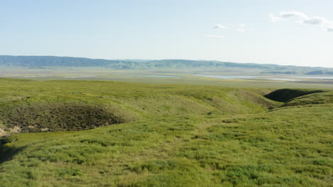 Sunshine-skyline-above-Carrizo-hills,-drone-fly-grassland-meadow-in-California-American-famous-historic-site