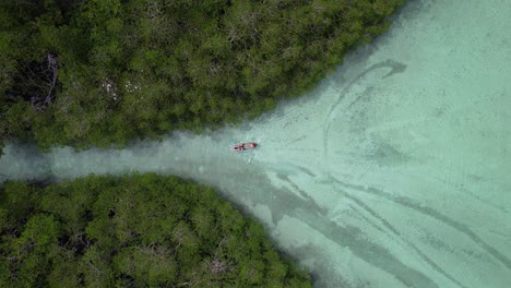 two-tourists-kayaking-on-a-turquoise-river-in-a-mangrove-forest-in-Belitung-Indonesia,-aerial-birds-eye-view