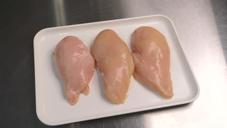 Fresh-chicken-meat-is-lying-on-a-tray,-ready-for-further-processing