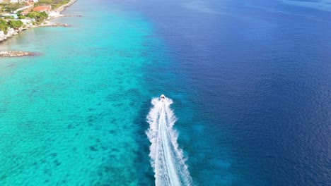 Speedboat-races-in-shallow-ocean-water-following-reef-drop-off-in-Curacao