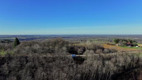 Aerial-shot-focused-on-a-motorhome-parked-on-a-road-in-the-countryside