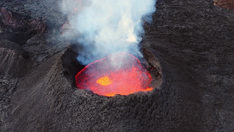 Smoking-volcano-crater-with-bursting-red-hot-lava-in-ashen-landscape