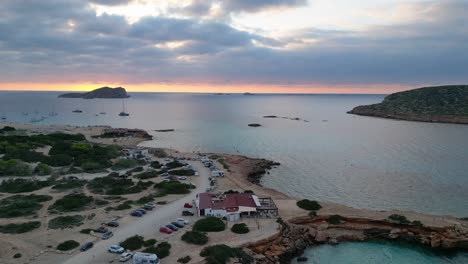 Strand-Von-Cala-Comte-Mit-Booten,-Atemberaubender-Sonnenuntergangshimmel-Auf-Ibiza