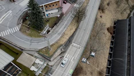 Gondolas-moving-above-the-road-and-buildings-in-Morzine,-France