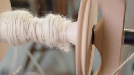 Close-up:-Spinning-wheel-bobbin-collects-wool-yarn-in-modern-craft