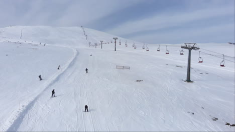 Vista-De-Drones-De-Esquiadores-Esquiando-Cuesta-Abajo-En-Las-Laderas-De-La-Pintoresca-Montaña-Kaimaktsalan-Grecia-Día-De-Invierno