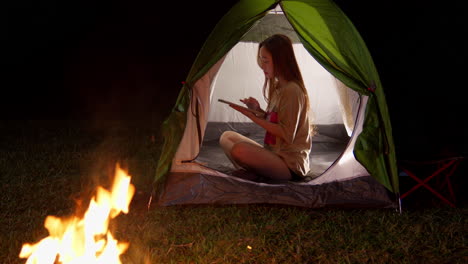 Frau-Asiatische-Mädchen-Chatten-In-Ihrem-Zelt-Camping-Im-Freien-In-Der-Nacht-Mit-Lagerfeuer