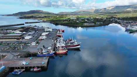 Drone-Volando-Sobre-El-Puerto-De-Castletownbere-Con-Barcos-Pesqueros-Preparados-Para-Descargar-E-Ir-Al-Mar-Nuevamente-A-Principios-De-La-Mañana-De-Verano-En-West-Cork,-Irlanda