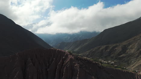 Vista-Aérea-Del-Valle-De-Purmamarca,-Drones-Volando-Entre-Altas-Montañas-En-La-Provincia-De-Jujuy,-Argentina