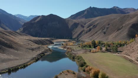 Drone-footage-of-a-remote-landing-strip,-bridge-over-a-river,-and-camp-surrounded-by-mouintains-and-a-river-in-the-Frank-Church-River-of-No-Return-Wilderness-in-Idaho