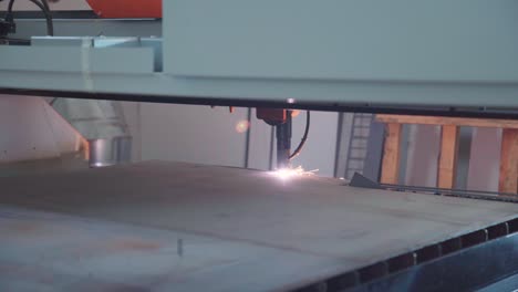 Plasma-CNC-cutting-machine-cutting-in-metal-plate,-close-up