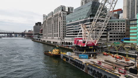 Floating-construction-vessel-in-front-of-the-FDR-drive,-East-river-NY---Drone-shot